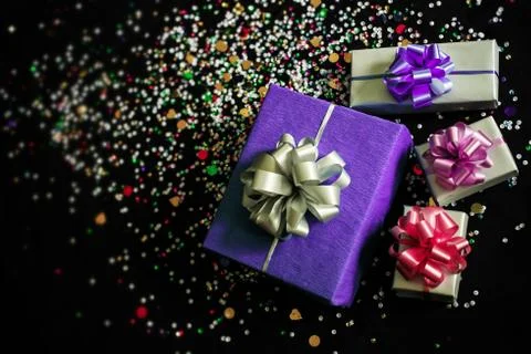 The gift boxes on a black festive background with sparkles Stock Photos