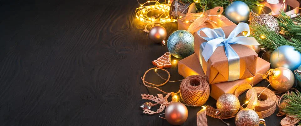 Gift boxes with blue ribbons and Christmas tree toys on a black background with Foto stock