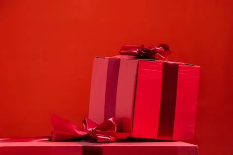 Gift boxes with a bow on a red background. Stock Photos