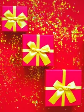 Gift boxes with bow on red-gold background Stock Photos