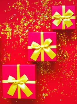 Gift boxes with bow on red-gold background Stock Photos