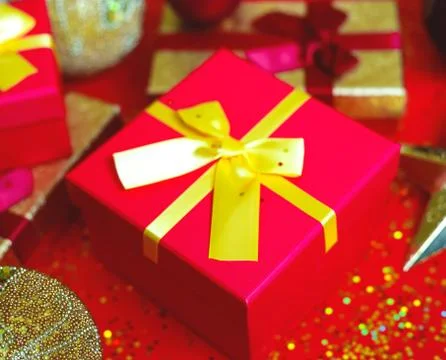 Gift boxes with bow on red-gold background Stock Photos