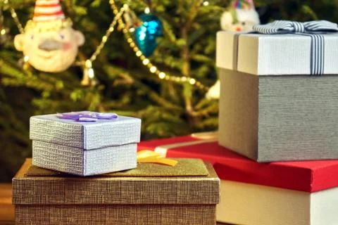 Gift boxes with bows on the lids under a Christmas tree in New Year Eve Photos