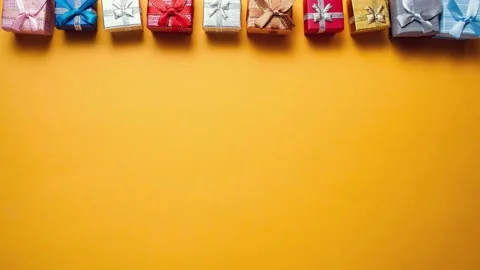 Gift boxes falling down on the yellow background. Stop motion Stock Footage 142027063