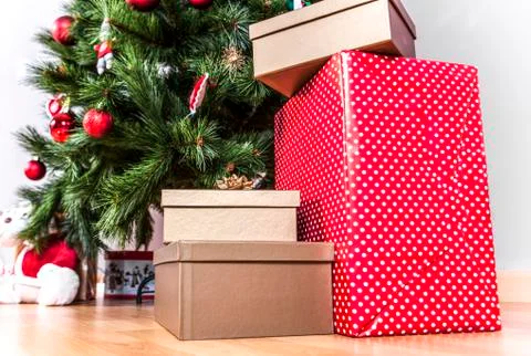 Gift boxes on the floor on a Christmas tree background Stock Photos