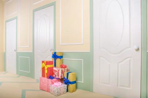 Gift boxes go under the door in a bright room Stock Photos