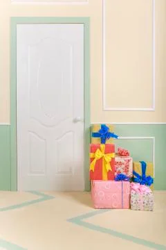 Gift boxes go under the door in a bright room Stock Photos