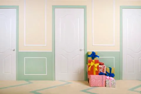 Gift boxes go under the door in a bright room Stock Photos