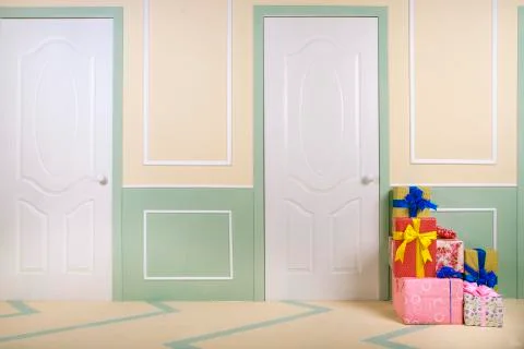 Gift boxes go under the door in a bright room Stock Photos