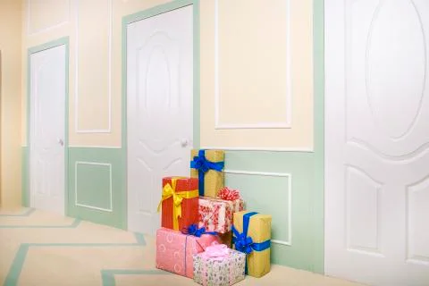 Gift boxes go under the door in a bright room Stock Photos