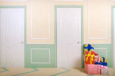 Gift boxes go under the door in a bright room Stock Photos