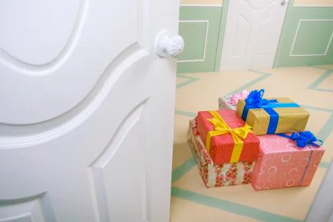 Gift boxes go under the door in a bright room Stock Photos