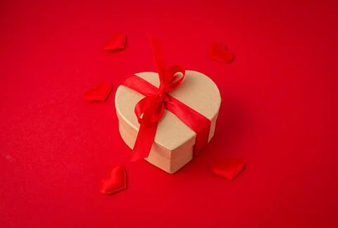 Gift boxes in heart shape with bow on red background, Saint Valentine Day Stock Photos