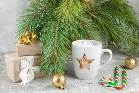 Gift boxes, hot drink with marshmallows, candy canes and golden balls on shab Stock Photos