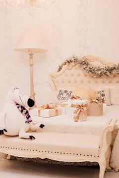 Gift boxes on a large bright bed in the Christmas bedroom Stock Photos