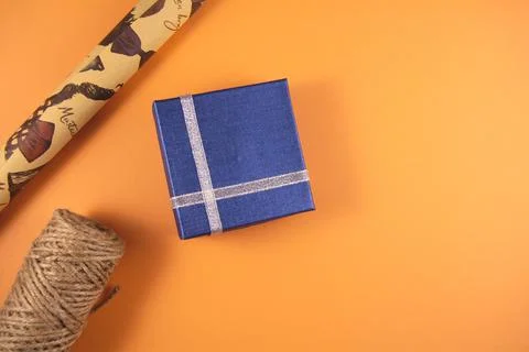 Gift boxes, paper's rools and rope on orange backgruond. Stock Photos