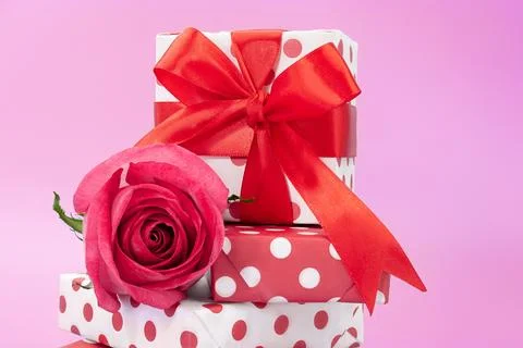 Gift boxes with polka dot on top of each other with bow and pink rose on back Stock Photos