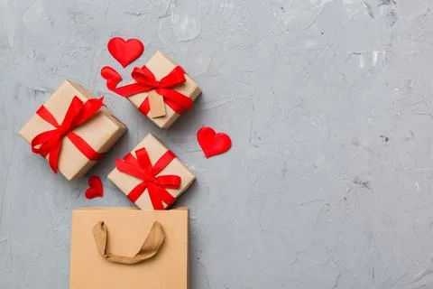 Gift boxes pop out from paper bag top view on colored background. bag packi.. Fotos Stock
