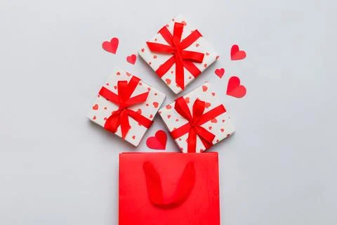 Gift boxes pop out from paper bag top view on colored background. bag packi.. Stock Photos