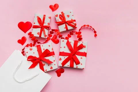 Gift boxes pop out from paper bag top view on colored background. bag packing Stock Photos