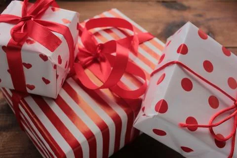 Gift boxes in red and white wrapping paper on table Stock Photos
