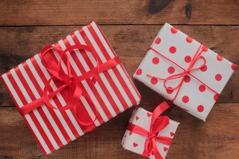 Gift boxes in red and white wrapping paper on table Stock Photos