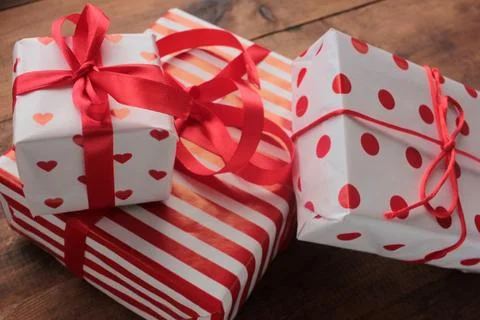 Gift boxes in red and white wrapping paper on wooden table Stock Photos