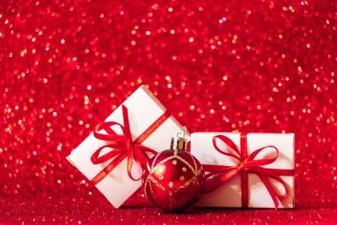 Gift boxes on red glittering background. Christmas concept, place for text. Stock Photos