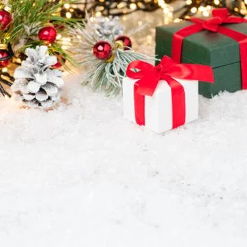Gift boxes with a red ribbon under Christmas tree decorated with red balls and Stock Photos