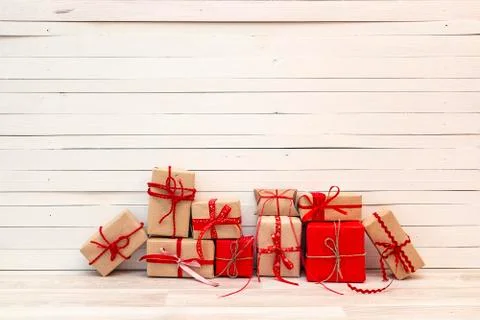 Gift boxes with red ribbons on white wooden background. Copy space. Stock Photos