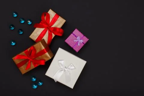 Gift boxes with ribbons on black background. Stock Photos