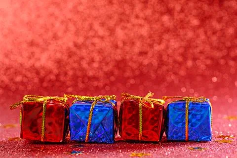 Gift boxes in row on red shiny background, copy space, christmas composition Stock Photos