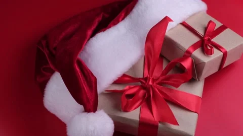 Gift boxes in Santa hat on red background. Concept of New Year and Christmas and Stock Footage 167559950