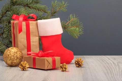 Gift boxes, Santa's boot and fir tree branch on gray background Stock Photos