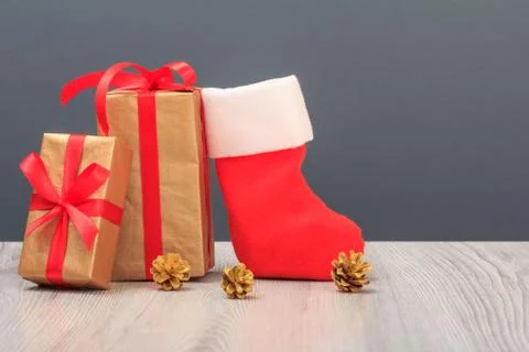 Gift boxes, Santa's boot and cones on gray background Stock Photos