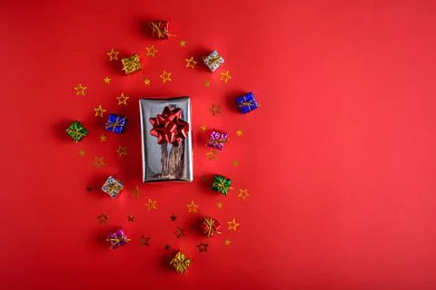Gift boxes with sequins on red background, copy space Stock Photos