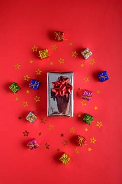 Gift boxes with sequins on red background, top view, vertical Stock Photos