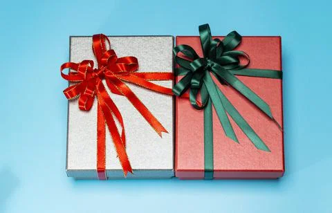 Gift boxes silver and red with red, green ribbon on the cyan background. Top Stock Photos