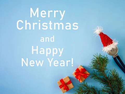 Gift boxes, stethoscope in Santa hat and Christmas tree on blue background Foto stock