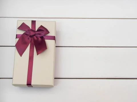 Gift boxes tied with red ribbons on a white wooden table. Stock Photos