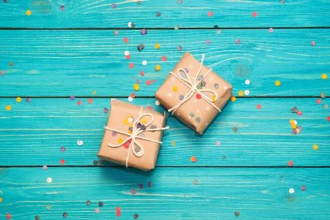 Gift boxes on turquoise wooden background with confetti. Stock Photos