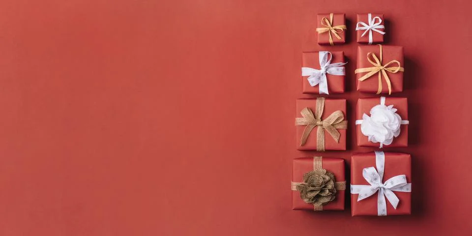 Gift boxes with white and brown bows on a red backdrop. Foto stock