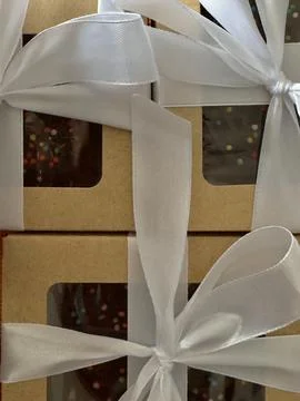 Gift boxes with white silk bow close-up Stock Photos
