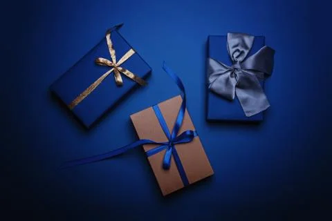 Gift boxes wrapped in classic blue paper with a gold, blue and grey ribbons. Stock Photos