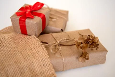 Gift boxes wrapped in craft paper with red ribbon and natural rustic rope on  Stock Photos