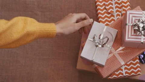 Gift boxes wrapped in gift paper. The girl takes one gift. vintage background. Stock Footage 220771214