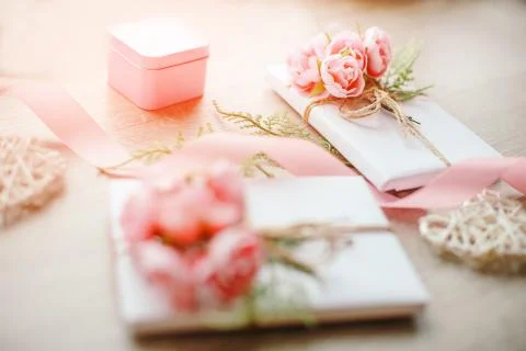 Gift boxes wrapped with simple white craft paper and bouquet of roses and gre Stock Photos