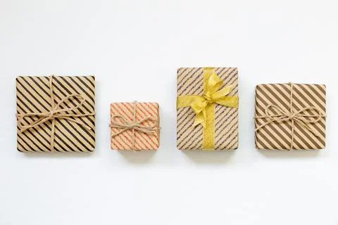 Gift boxes wrapped in striped kraft paper on white background Stock Photos