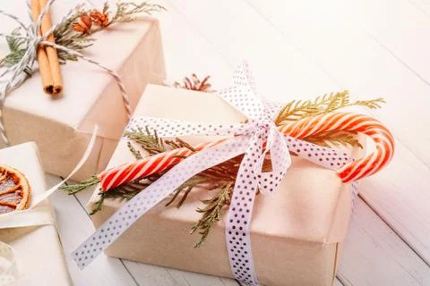 Gift boxes wrapped in wrapping paper with ribbons on a white wooden backgroun Stock Photos