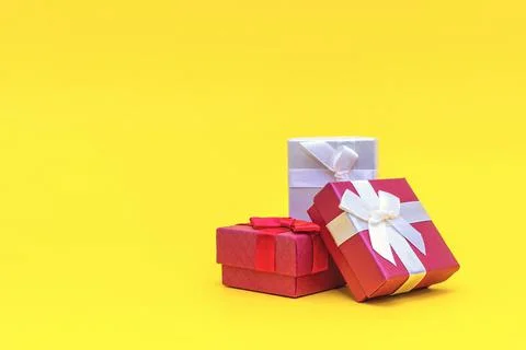 Gift boxes on a yellow background. Red gift boxes, open box. Postcard for pri Stock Photos